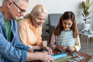 Grandmother putting puzzle together with granddaughter